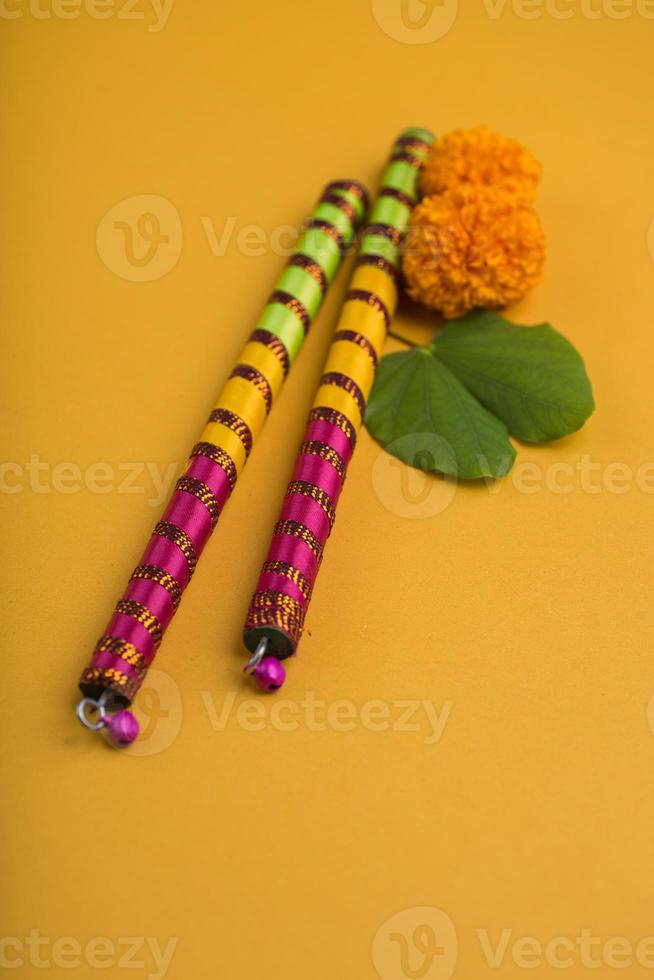 festival indien dussehra et navratri, montrant des fleurs de bauhinia racemosa et de souci avec des bâtons de dandiya. photo