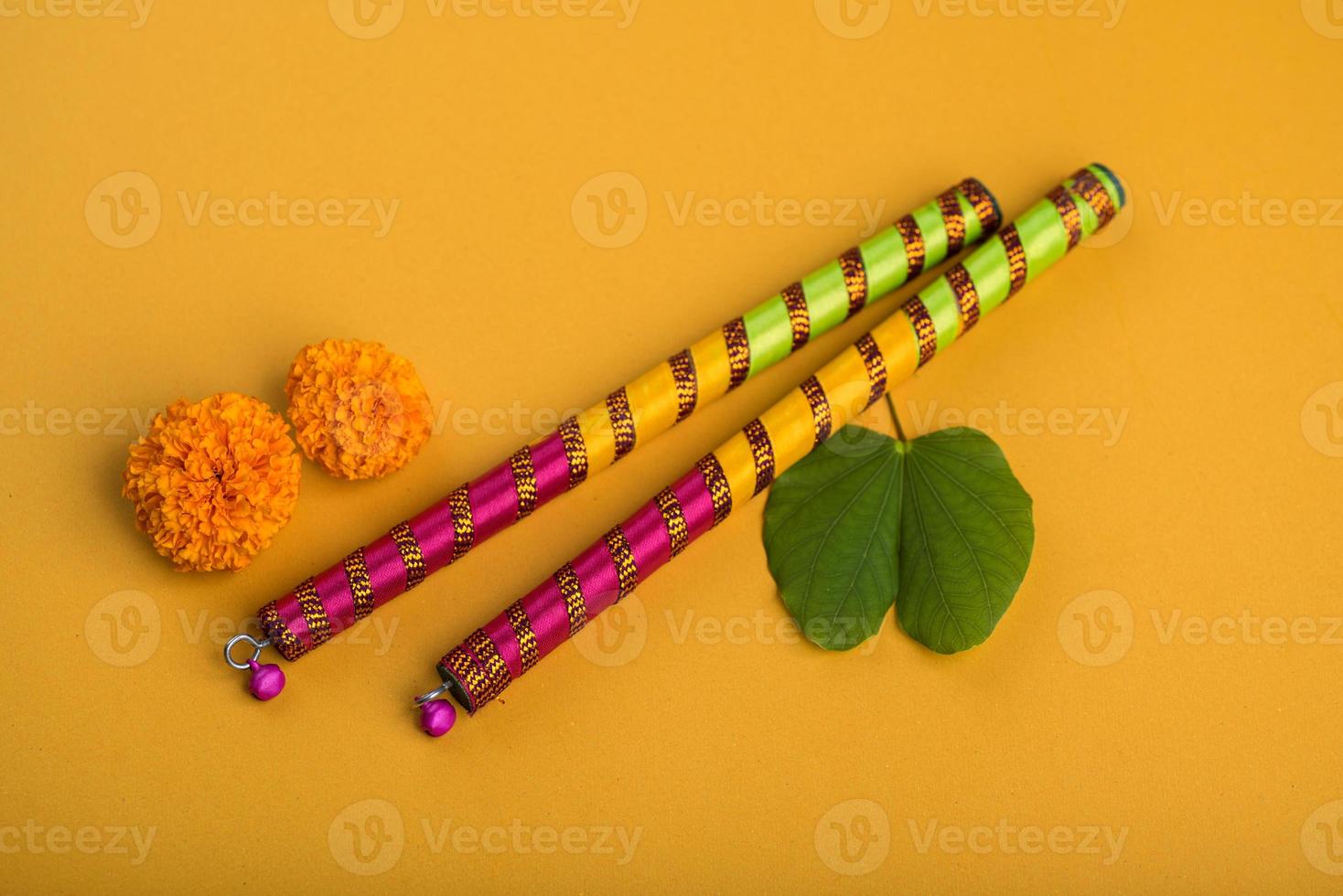 festival indien dussehra et navratri, montrant des fleurs de bauhinia racemosa et de souci avec des bâtons de dandiya. photo
