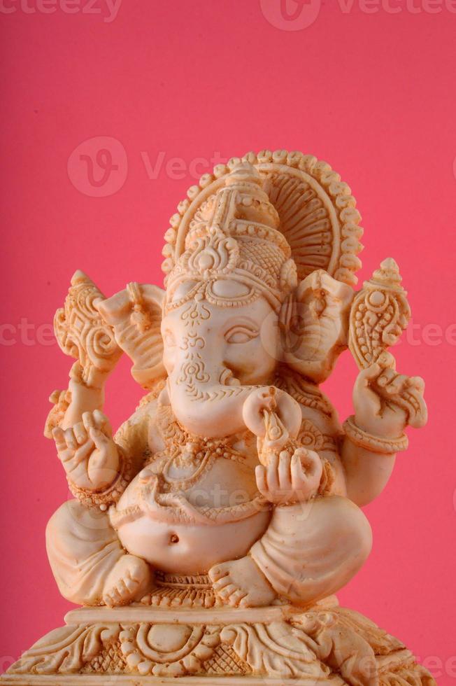 dieu hindou ganesha. idole de ganesha sur fond rose photo