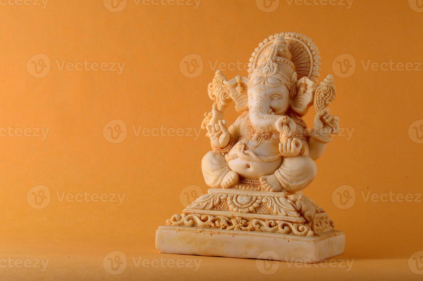 dieu hindou ganesha. idole de ganesha sur fond jaune photo