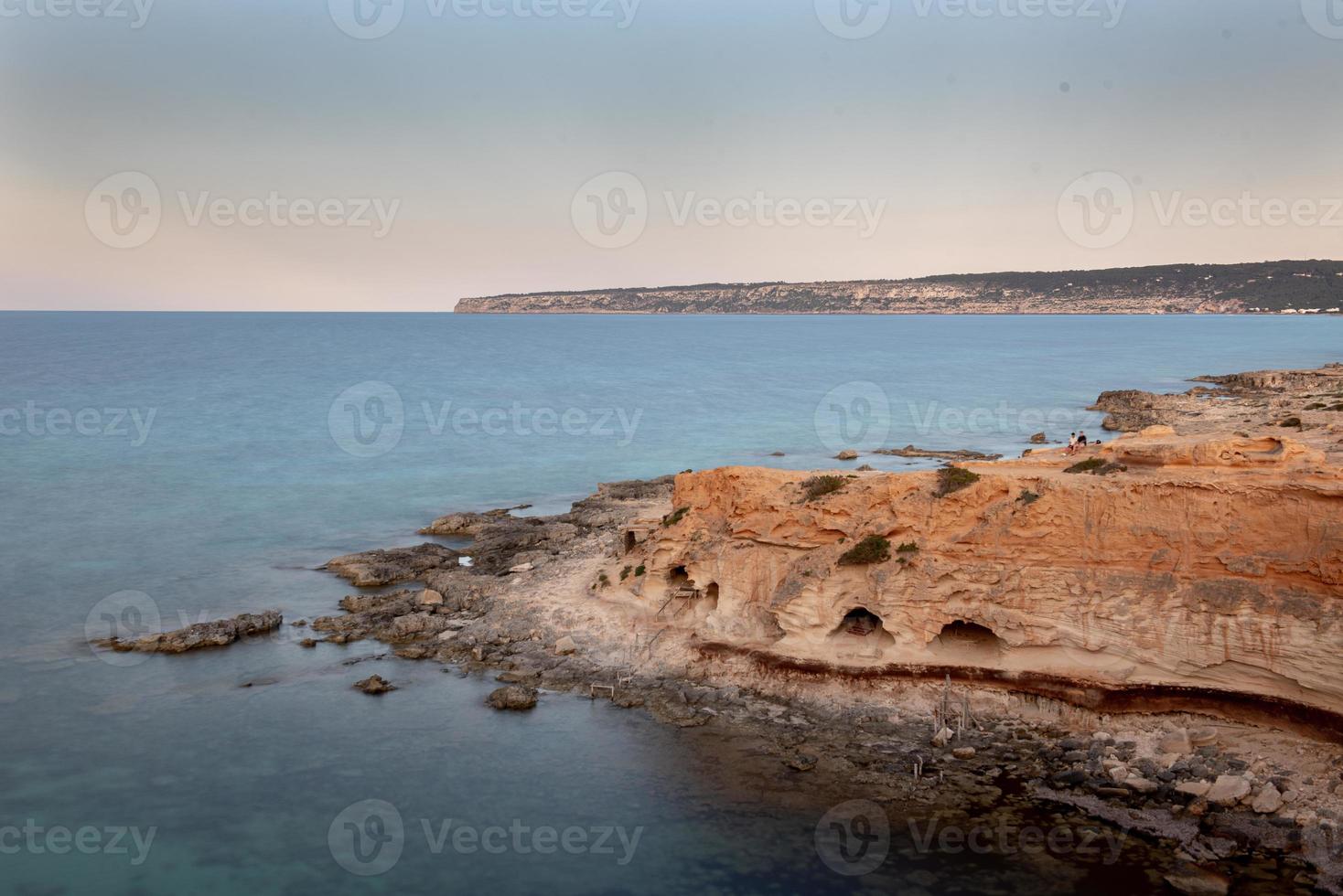 jeune homme dans la grotte de la belle cala d'en baster sur l'île de formentera dans les îles baléares en espagne. photo