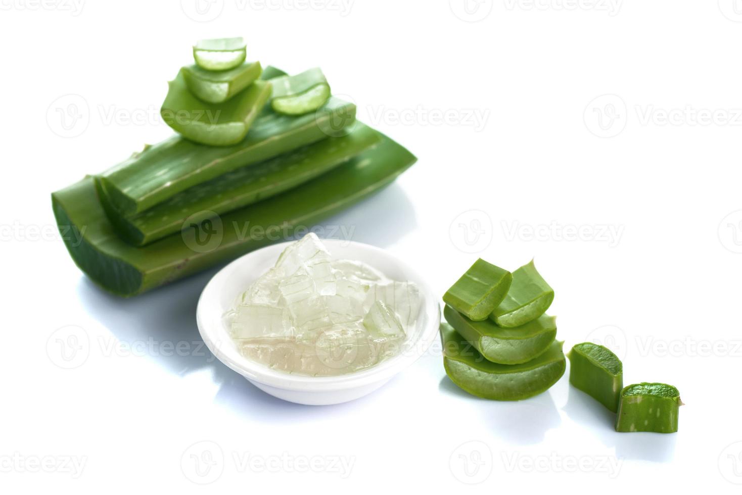 tranches de feuilles d'aloe vera et de gel d'aloe vera dans un bol sur fond blanc. L'aloe vera est un médicament à base de plantes très utile pour les soins de la peau et des cheveux. photo