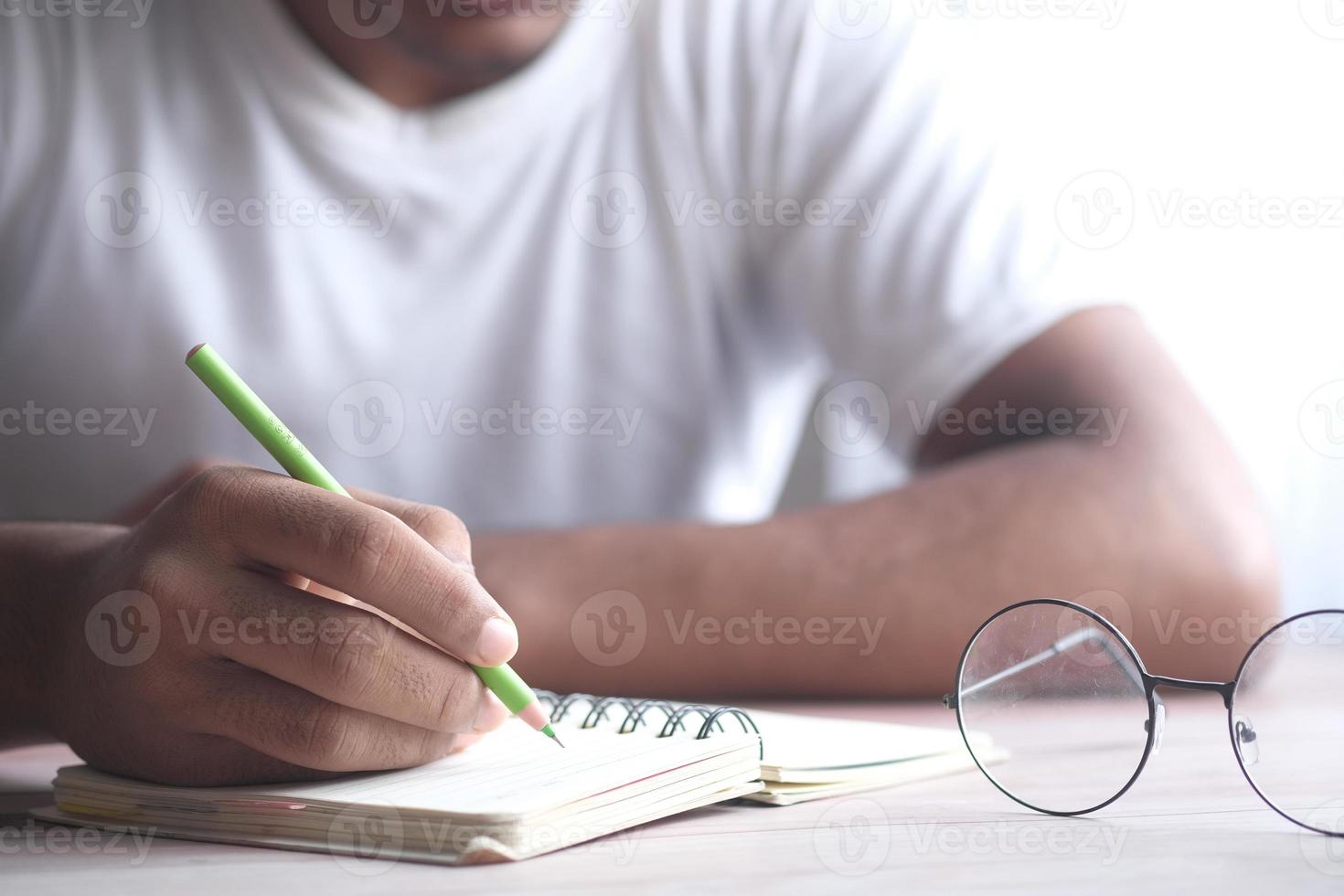 un étudiant écrit sur le bloc-notes tôt le matin photo