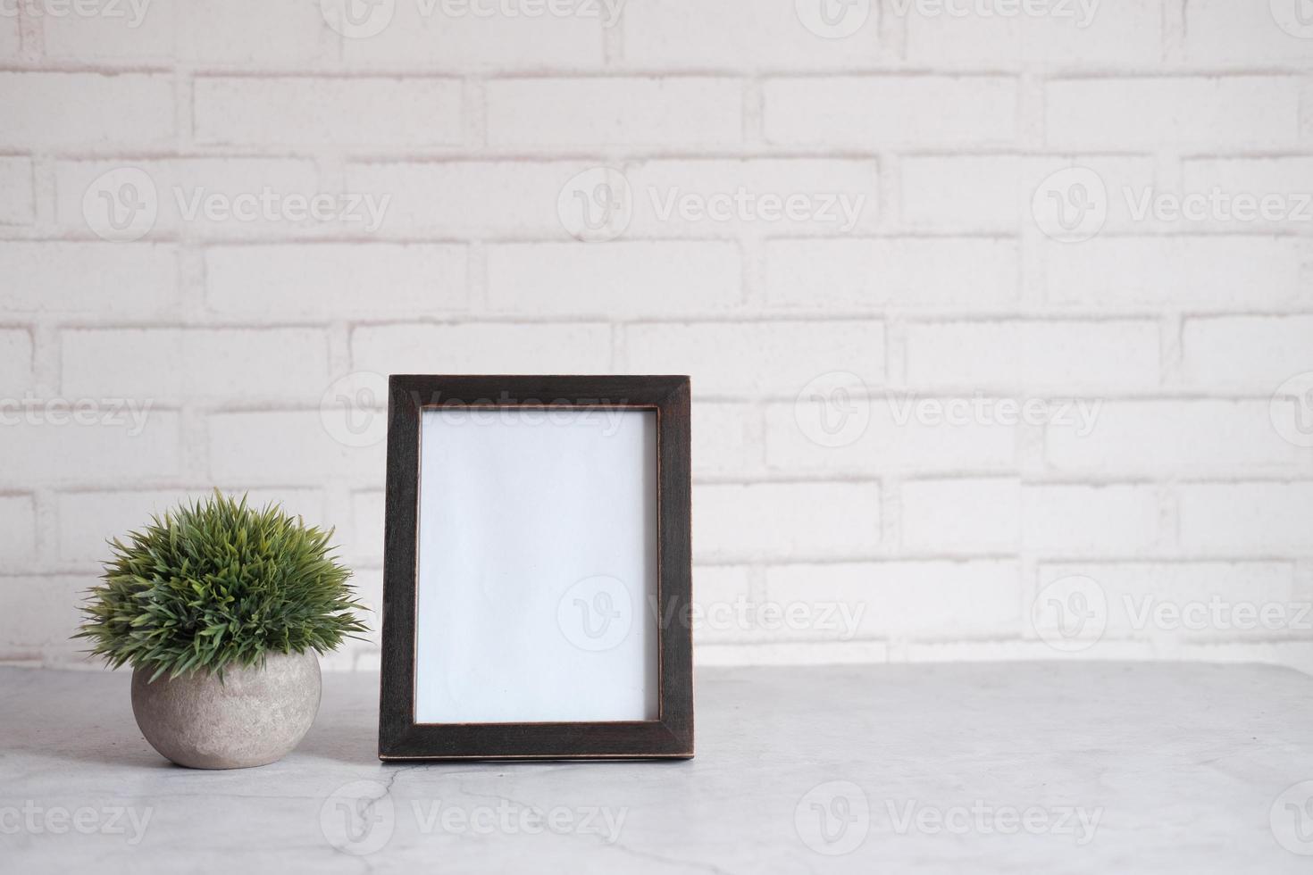 cadre vide sur table contre mur blanc photo