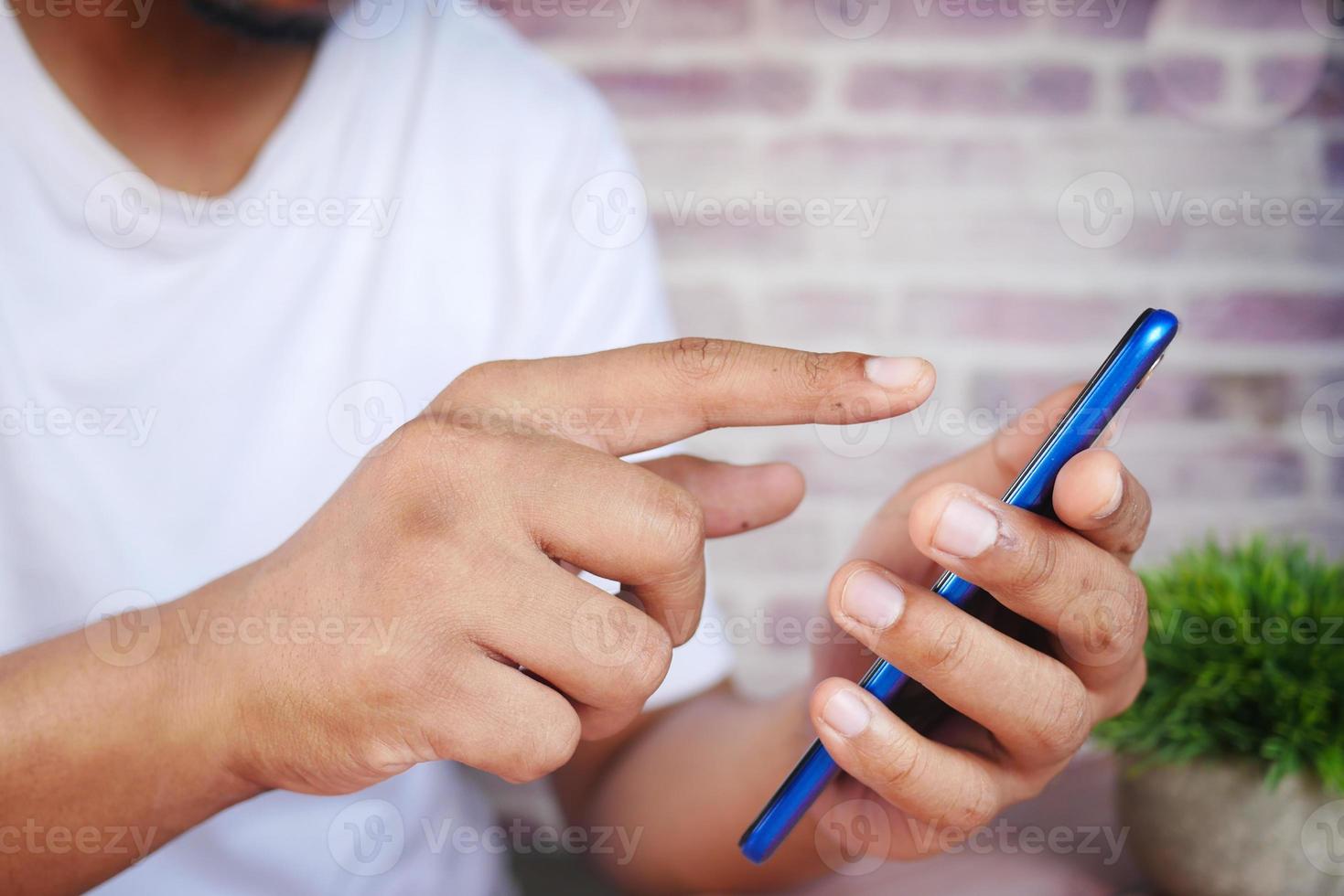 gros plan de la main du jeune homme à l'aide d'un téléphone intelligent. photo