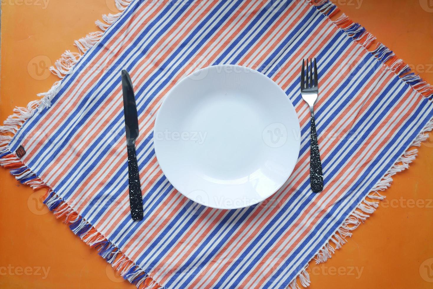 couverts et assiette vide sur fond de couleur de haut en bas photo