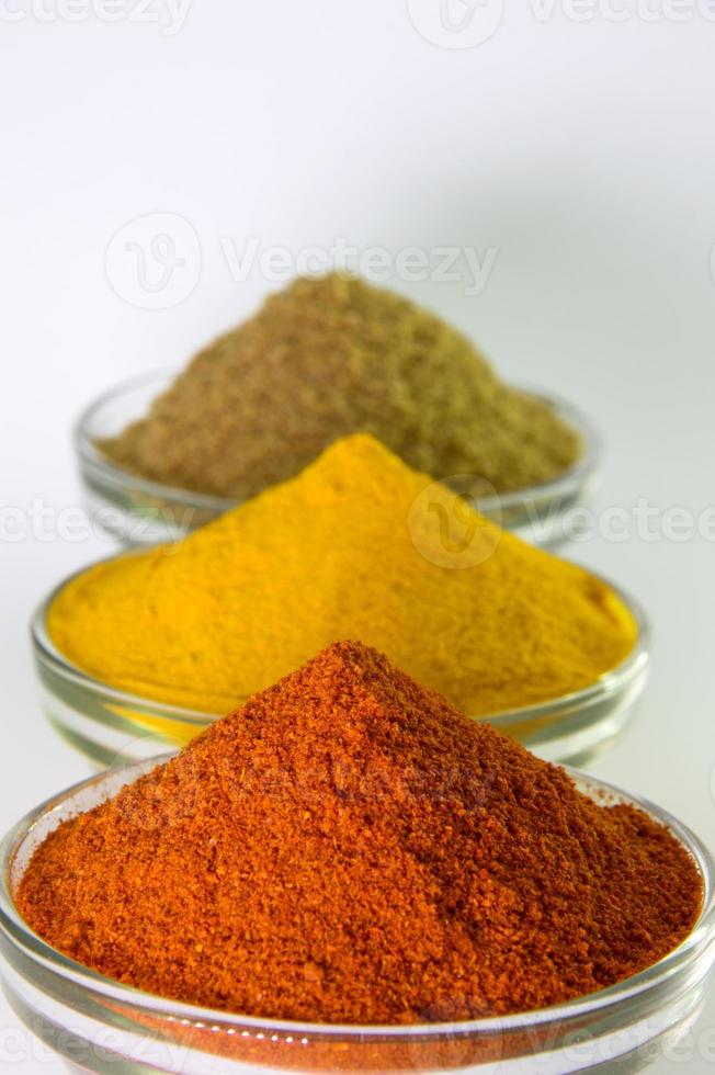 piment en poudre d'épices, curcuma et coriandre dans un bol isolé sur fond blanc. photo