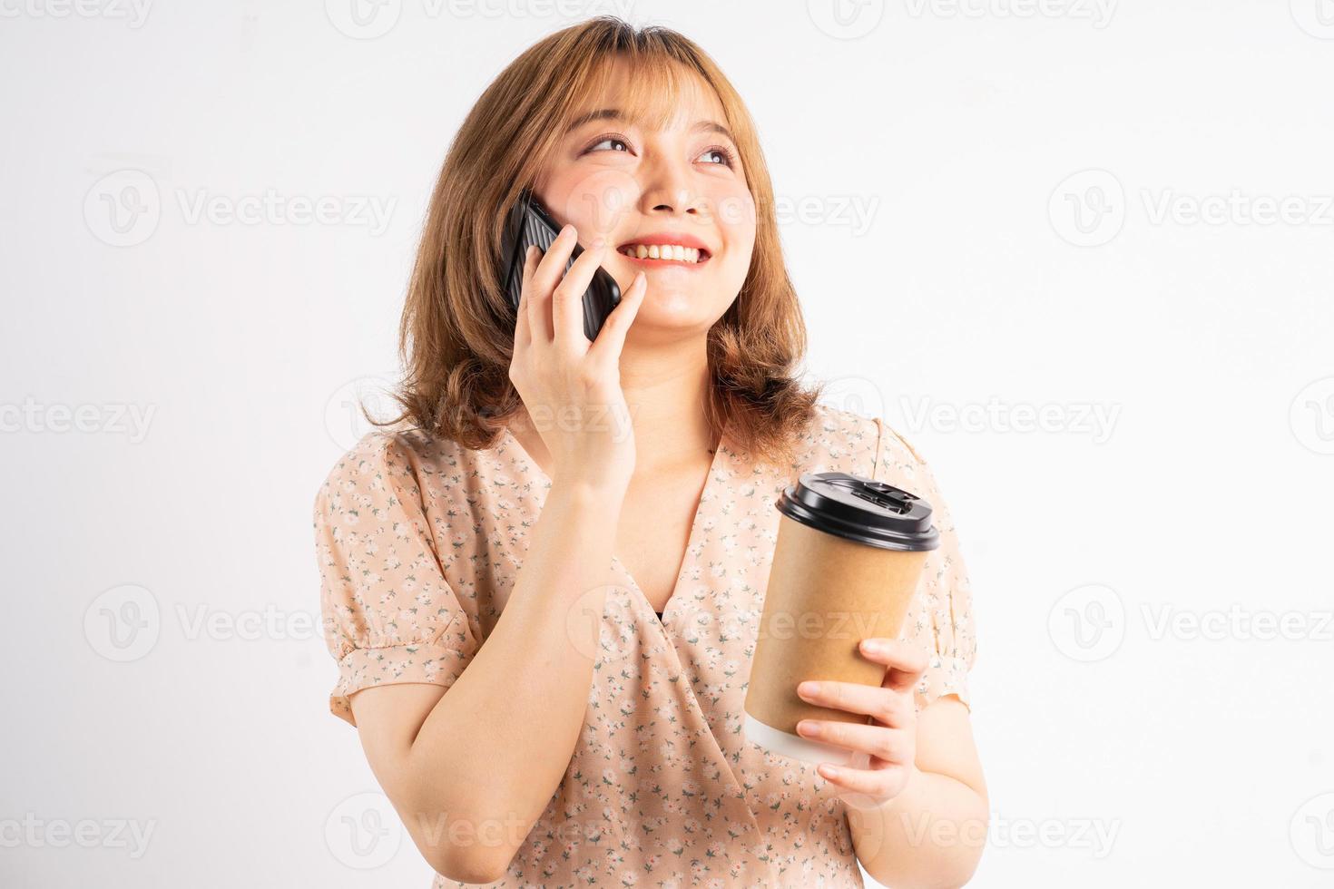 jeune fille tenant une tasse de café et écoutant le téléphone en arrière-plan photo