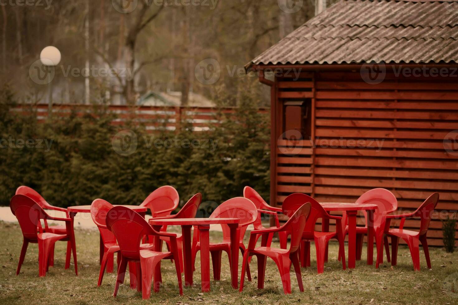 partie de une en bois bâtiment et une rangée de vide rouge chaises et les tables. photo