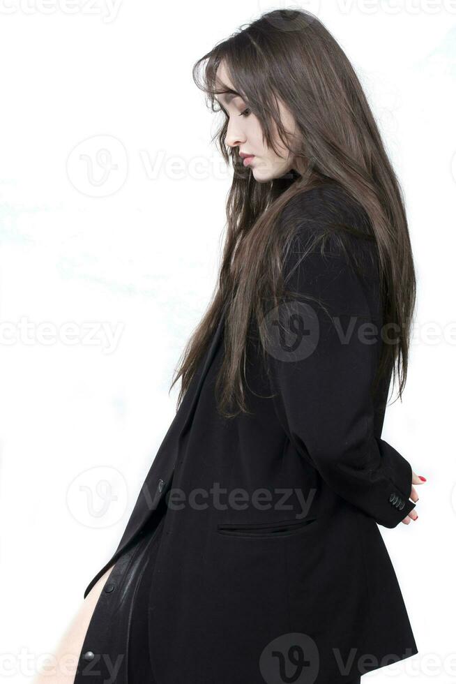 profil portrait de une magnifique fille avec longue cheveux dans une noir veste sur une blanc Contexte. photo