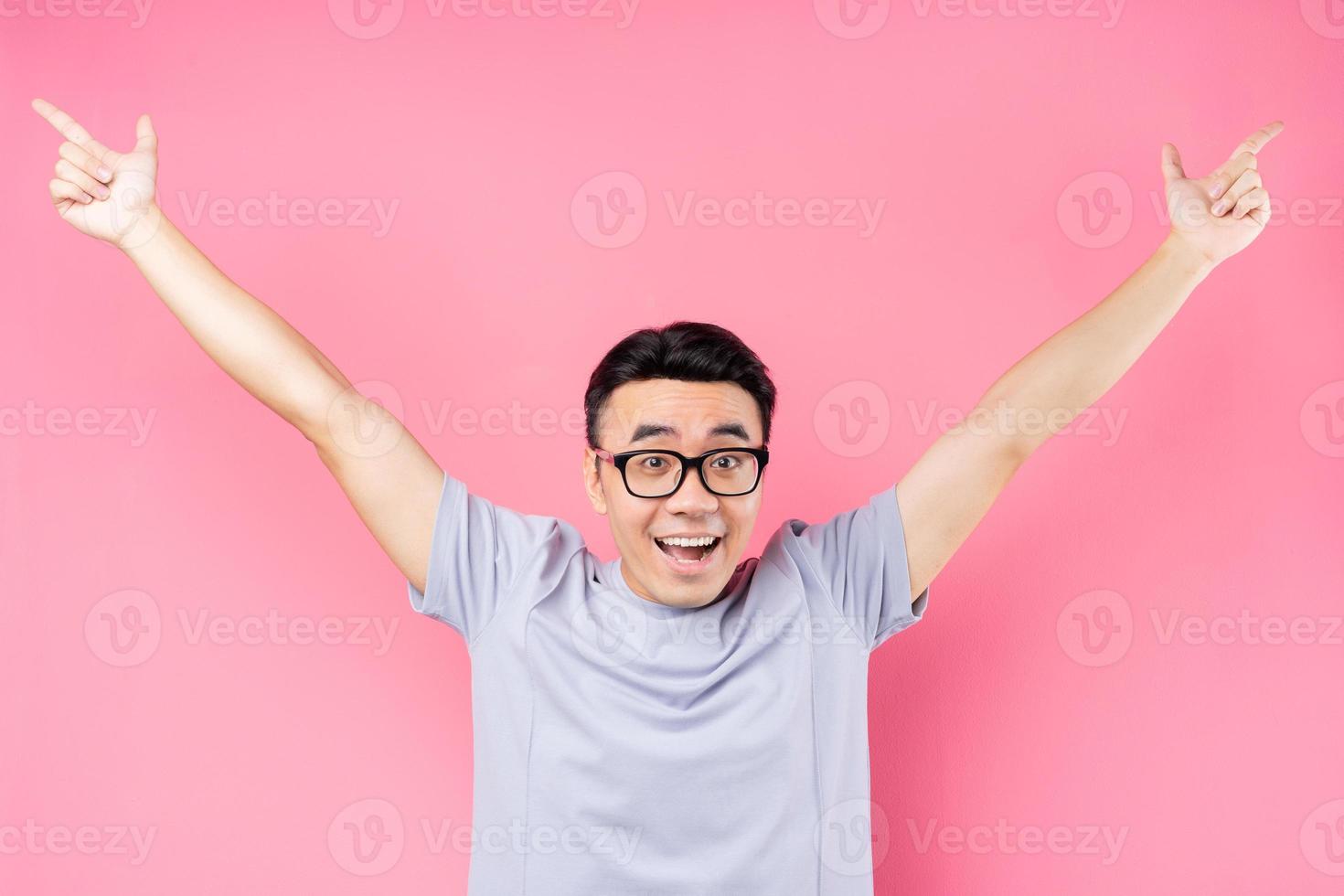 portrait d'un homme asiatique posant sur fond rose avec beaucoup d'expression photo