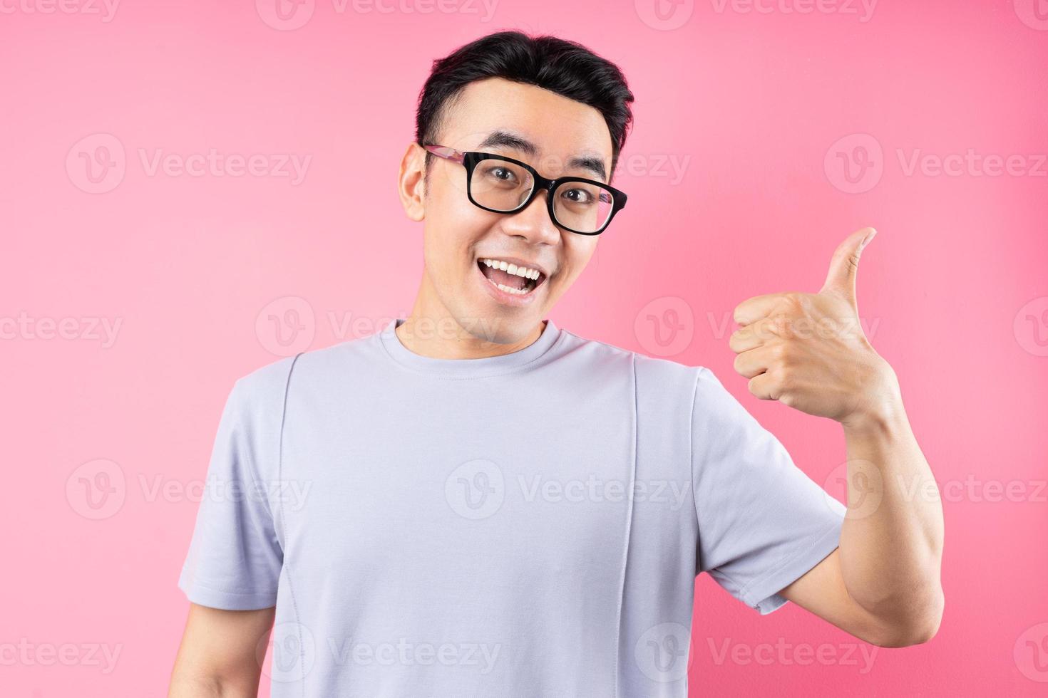 portrait d'un homme asiatique posant sur fond rose avec beaucoup d'expression photo
