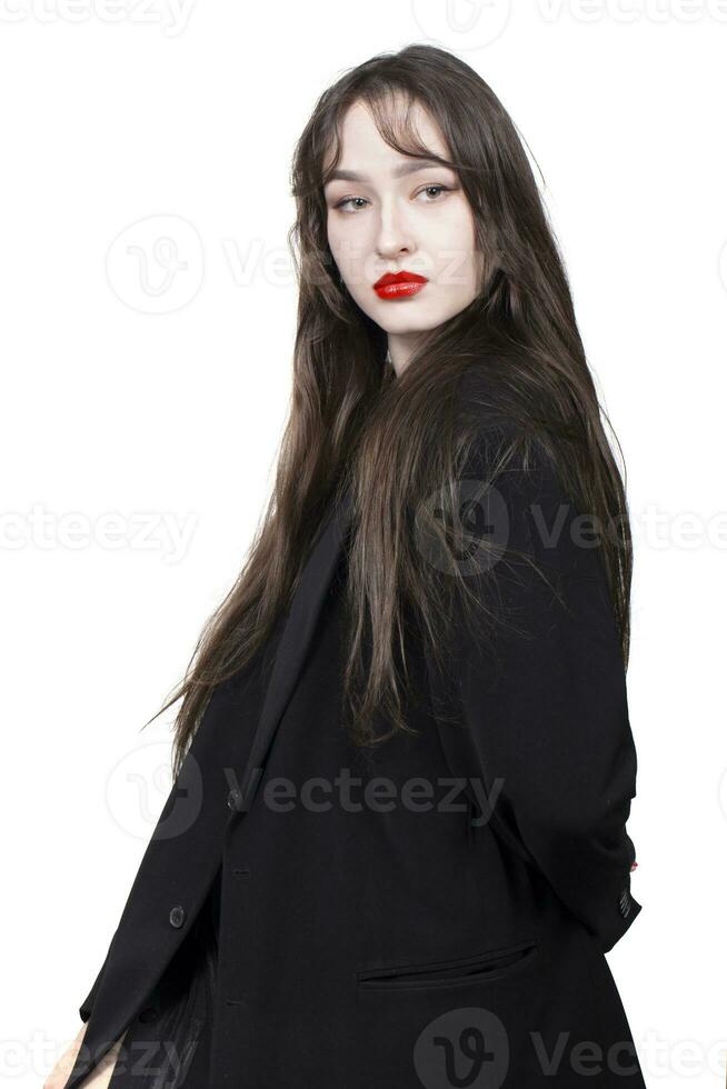 portrait de une magnifique fille avec longue cheveux dans une noir veste sur une blanc Contexte. photo