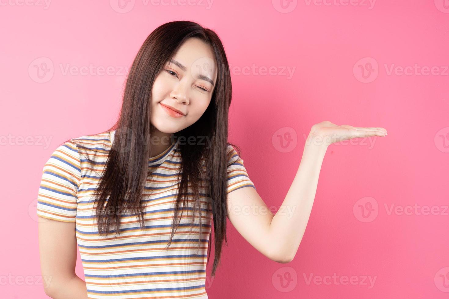 jeune femme asiatique posant sur fond rose photo