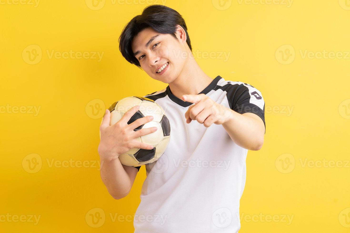 l'homme asiatique tenait le ballon et a pointé sa main photo