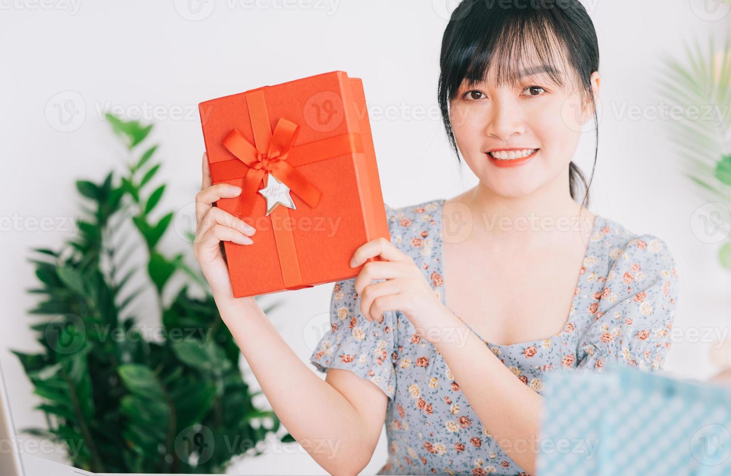 jeune femme asiatique en direct pour offrir des cadeaux au public qui la regarde sur les plateformes de réseaux sociaux photo