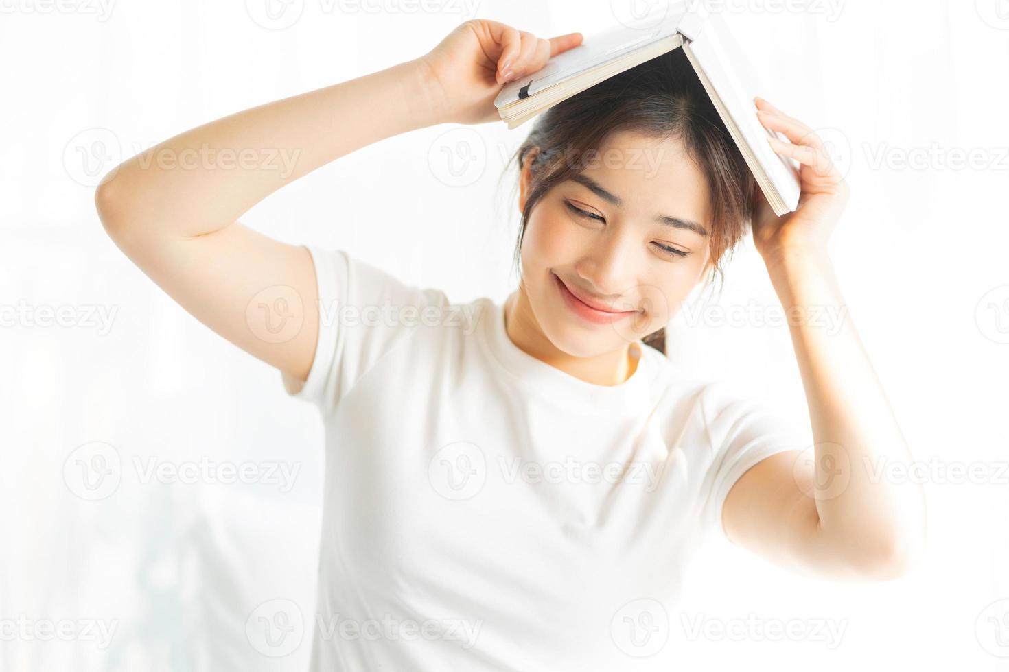 portrait d'une jeune fille asiatique lisant un livre et buvant du café photo