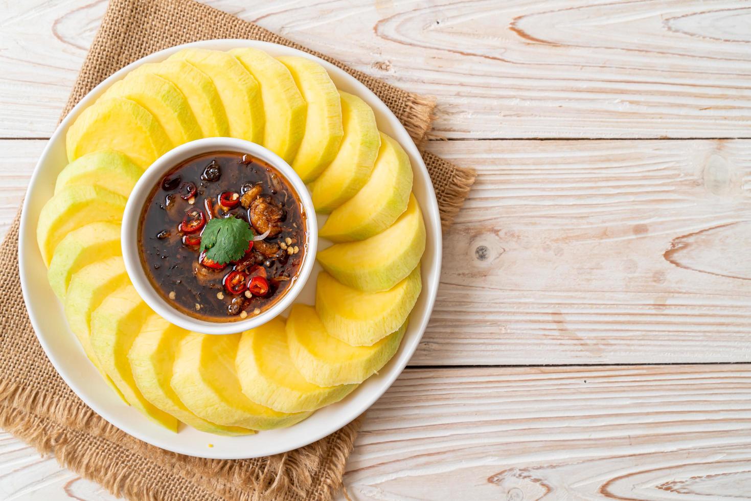 mangue verte et dorée fraîche avec trempette de sauce de poisson sucrée - style asiatique photo