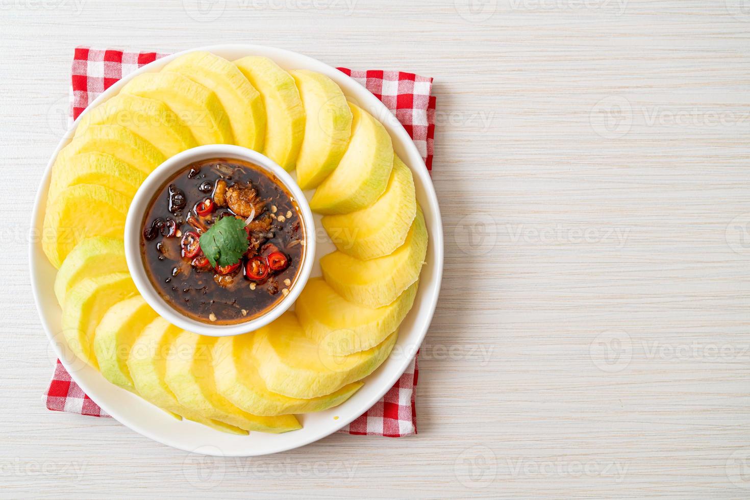 mangue verte et dorée fraîche avec trempette de sauce de poisson sucrée - style asiatique photo