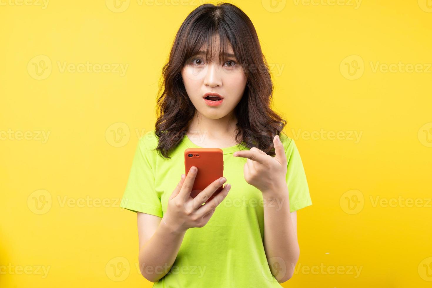 jeune fille utilisant un téléphone avec une expression surprise sur fond photo