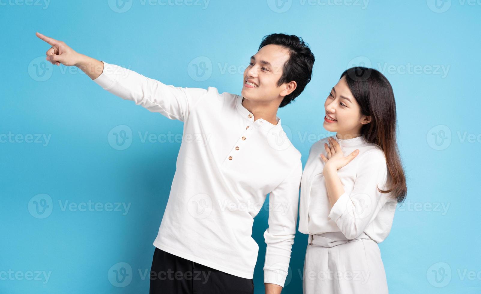 Portrait de jeune couple debout posant sur fond bleu photo