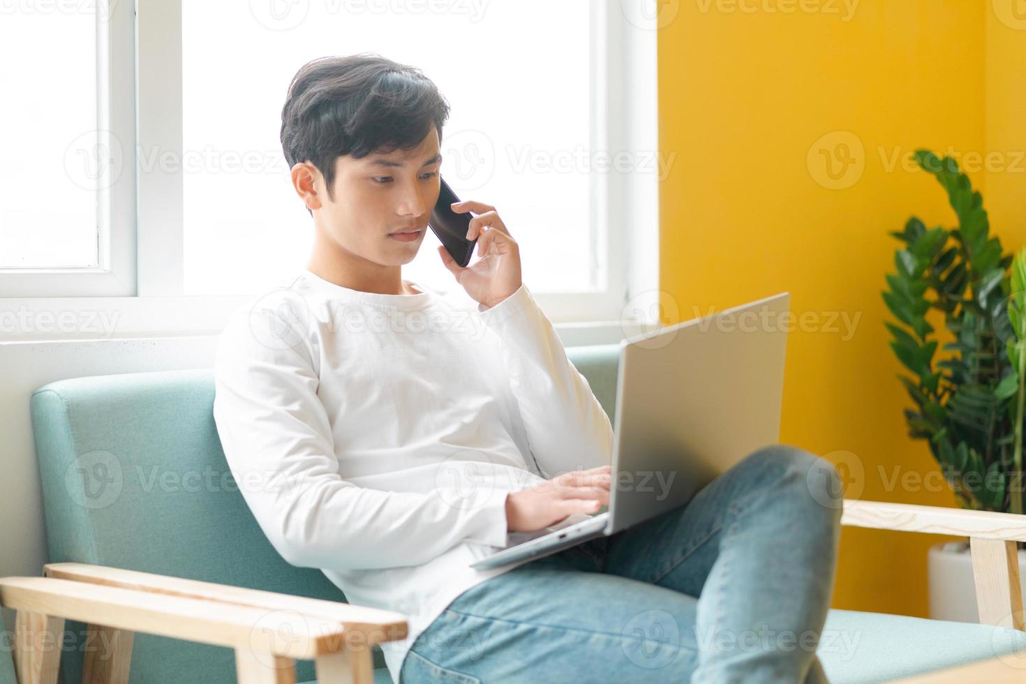 jeune homme asiatique assis travaillant à la maison photo