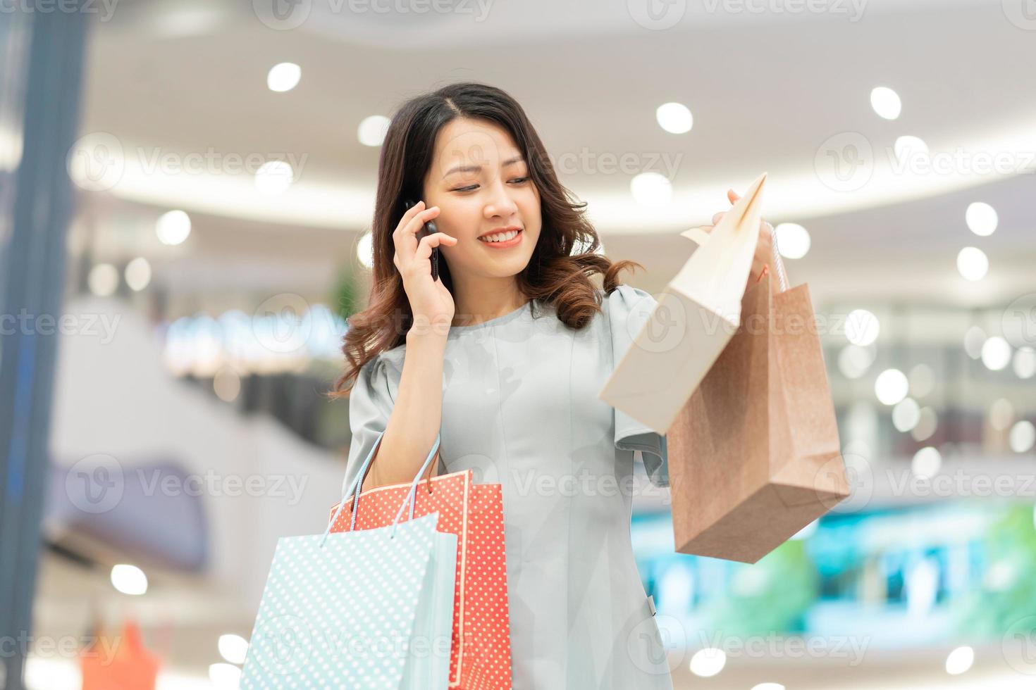 jeune fille fait du shopping et utilise le téléphone au centre commercial photo