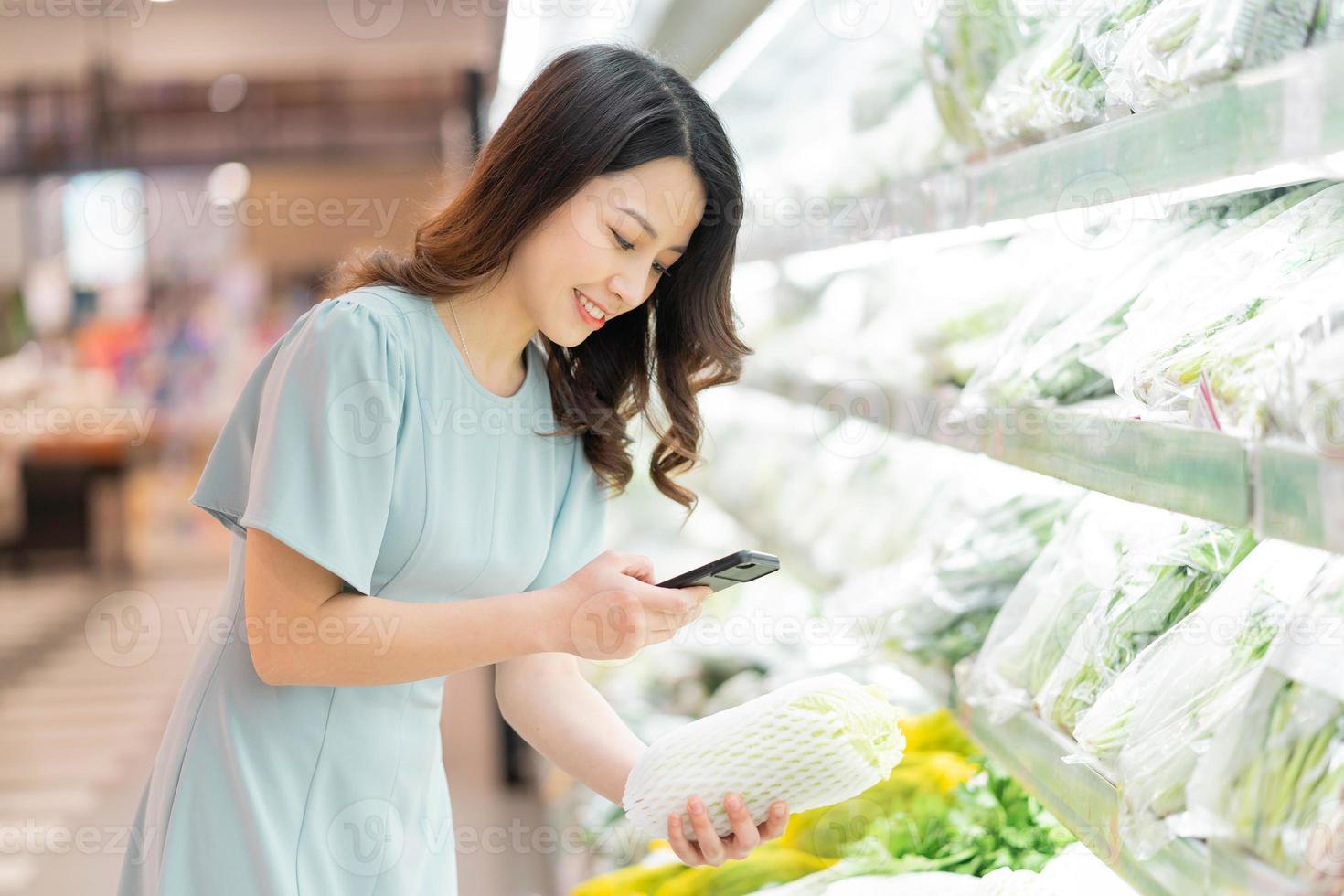 la jeune fille choisit d'acheter des légumes au supermarché photo