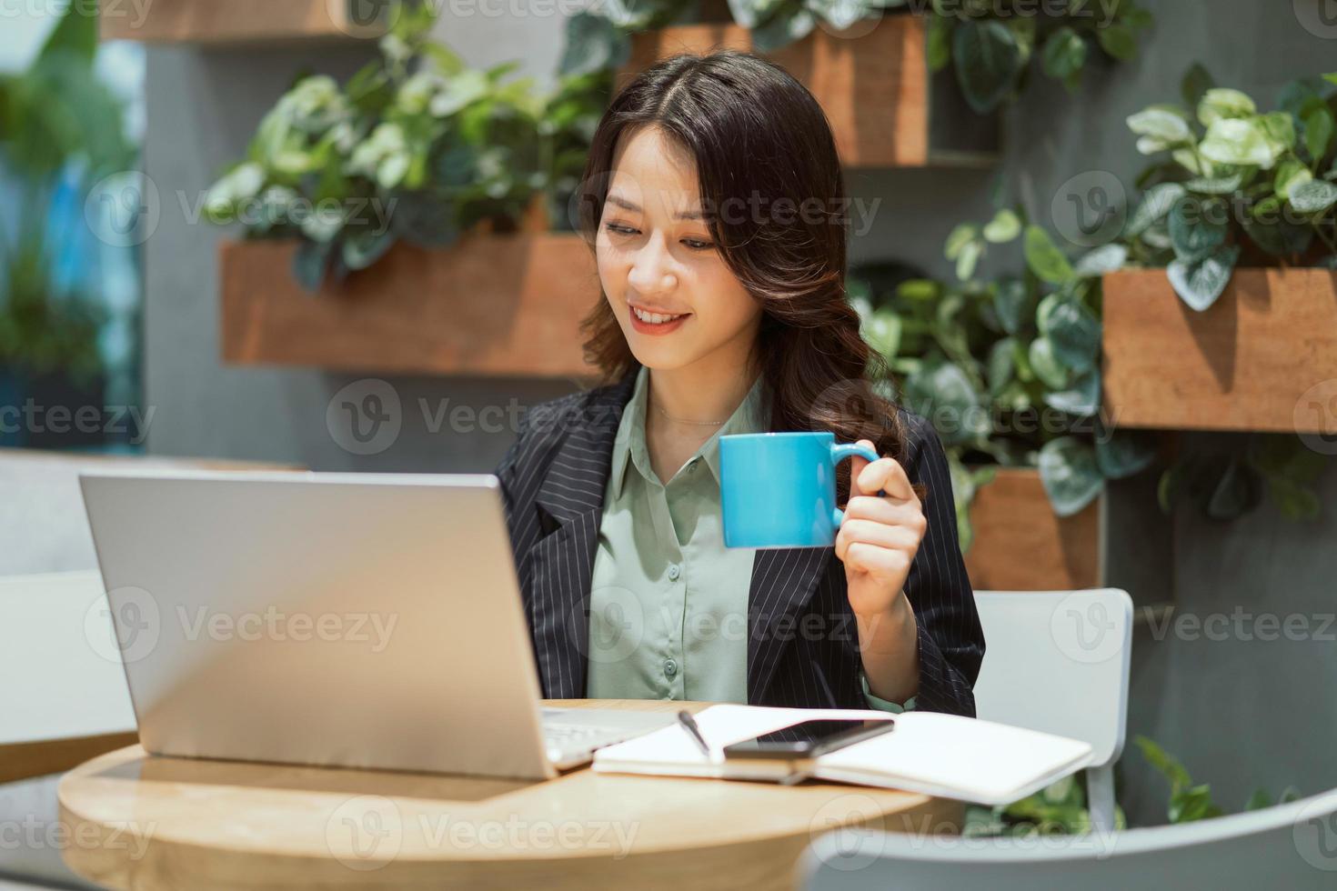 joyeuse jeune femme d'affaires travaillant au café photo