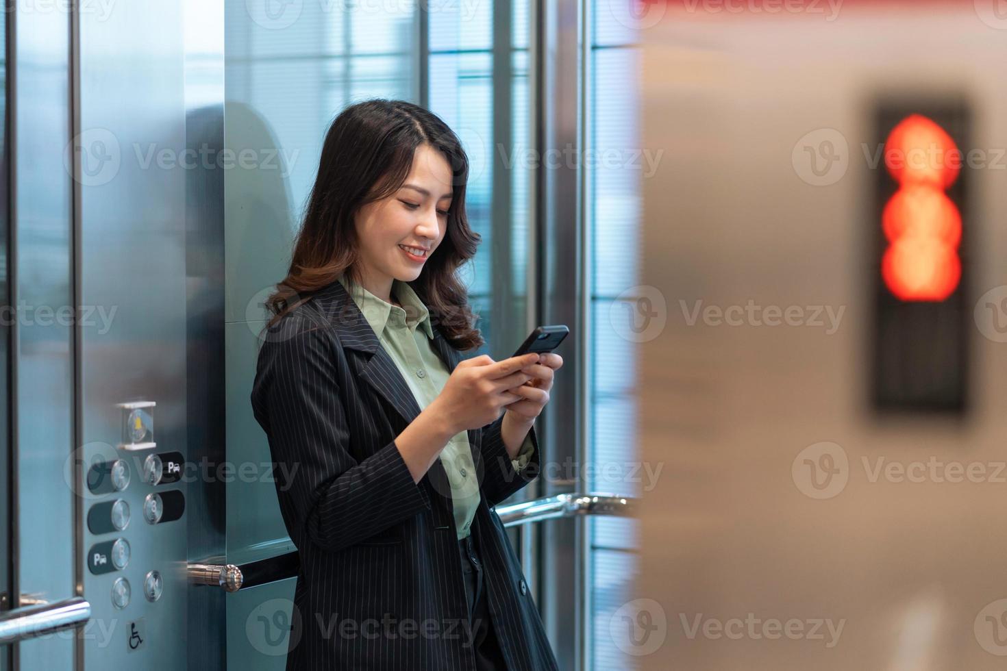 portrait, de, jeune, femme affaires, debout, dans, ascenseur, et, utilisation, téléphone photo