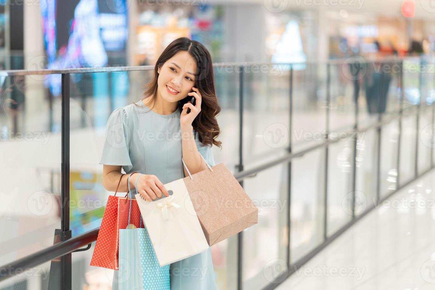 jeune fille fait du shopping et utilise le téléphone au centre commercial photo
