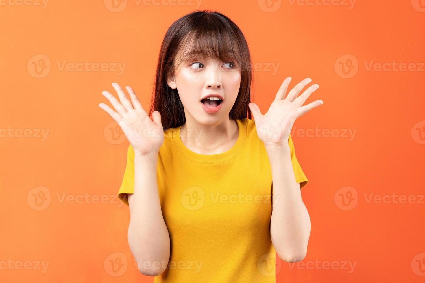 image de jeune fille asiatique portant un t-shirt jaune sur fond orange photo