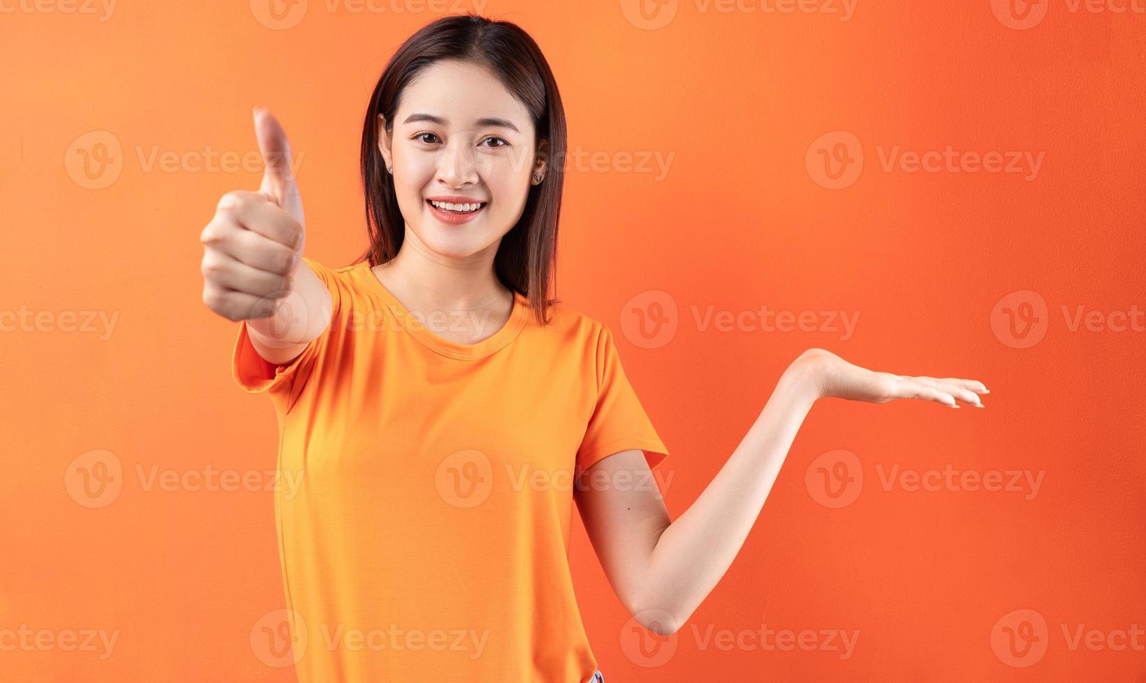 image de jeune femme asiatique portant un t-shirt orange sur fond orange photo