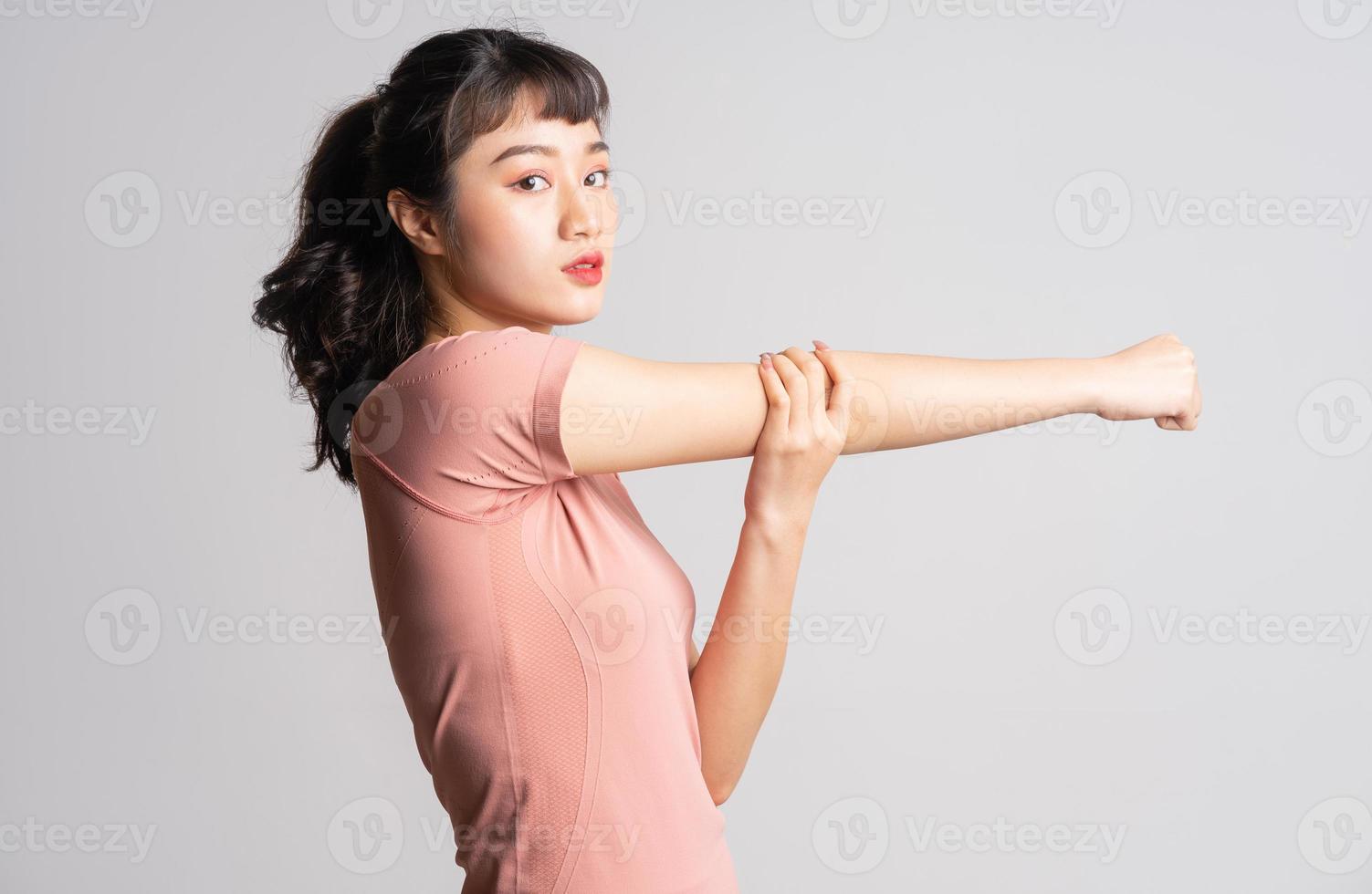 Jeune femme asiatique faisant de l'exercice sur fond blanc photo