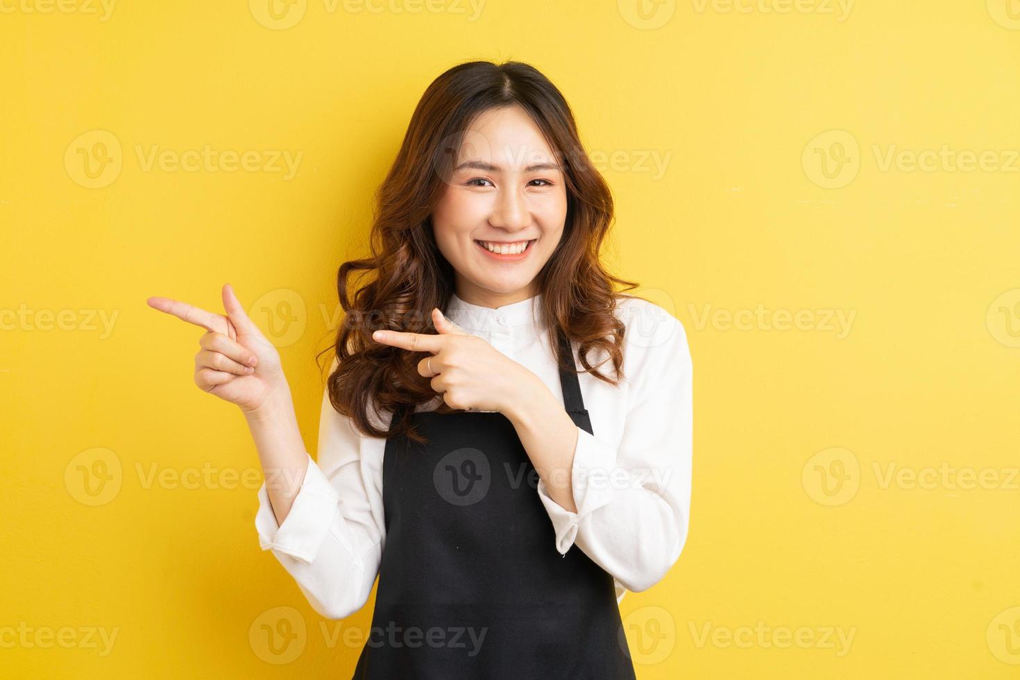 belle femme au foyer avec geste isolé sur fond jaune photo