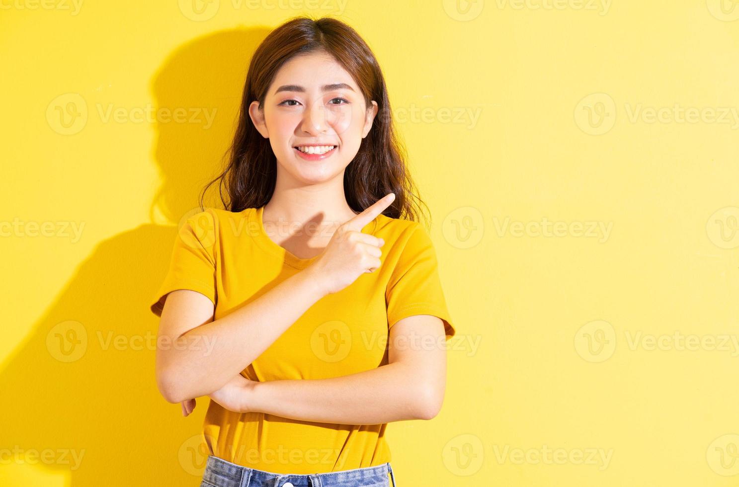 jeune fille asiatique posant sur fond jaune photo