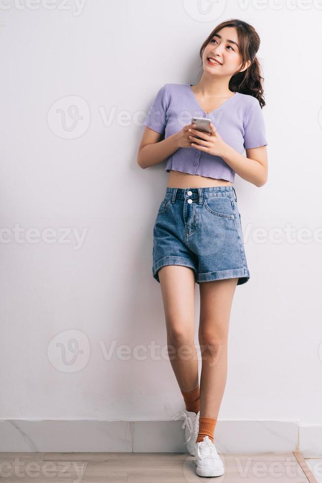 jeune femme asiatique à l'aide de smartphone sur fond blanc photo