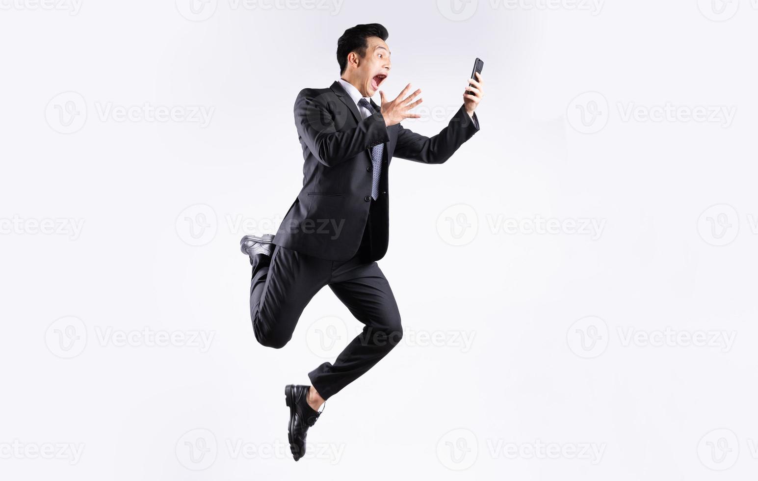 jeune homme d'affaires asiatique sautant sur fond blanc photo