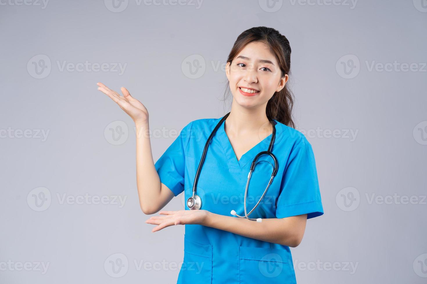 image de jeune femme médecin asiatique portant un uniforme bleu sur fond gris photo