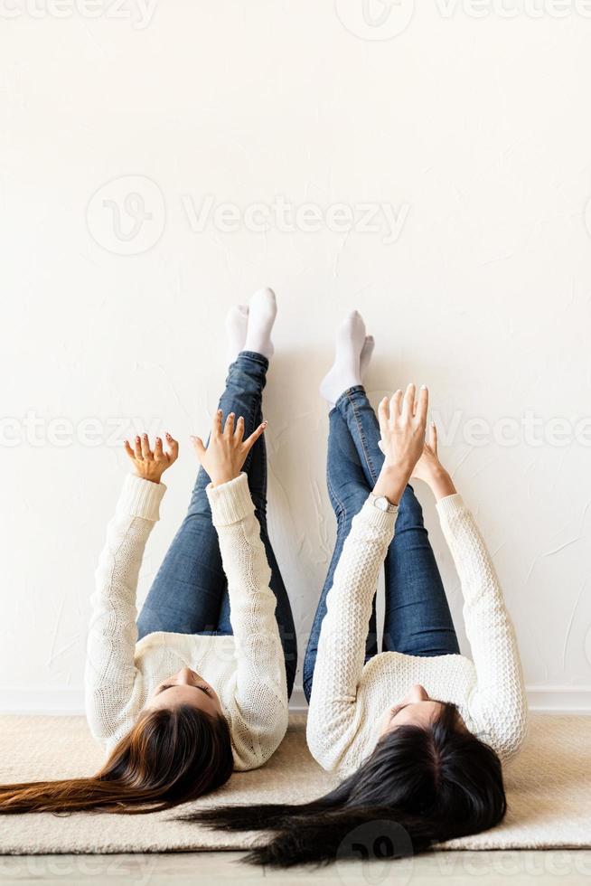 deux femmes allongées sur le tapis les jambes s'amusant photo