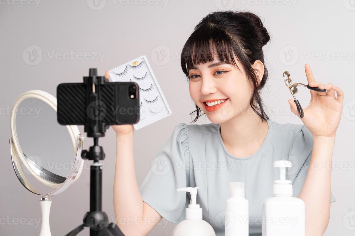jeune femme asiatique en direct pour enseigner le maquillage en ligne photo