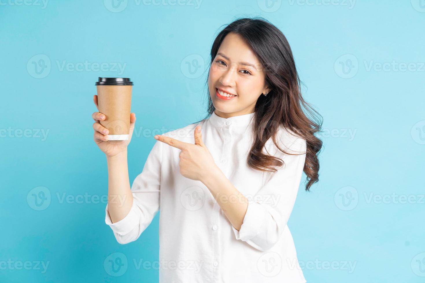 belle femme d'affaires asiatique tenant une tasse de café en papier dans sa main photo