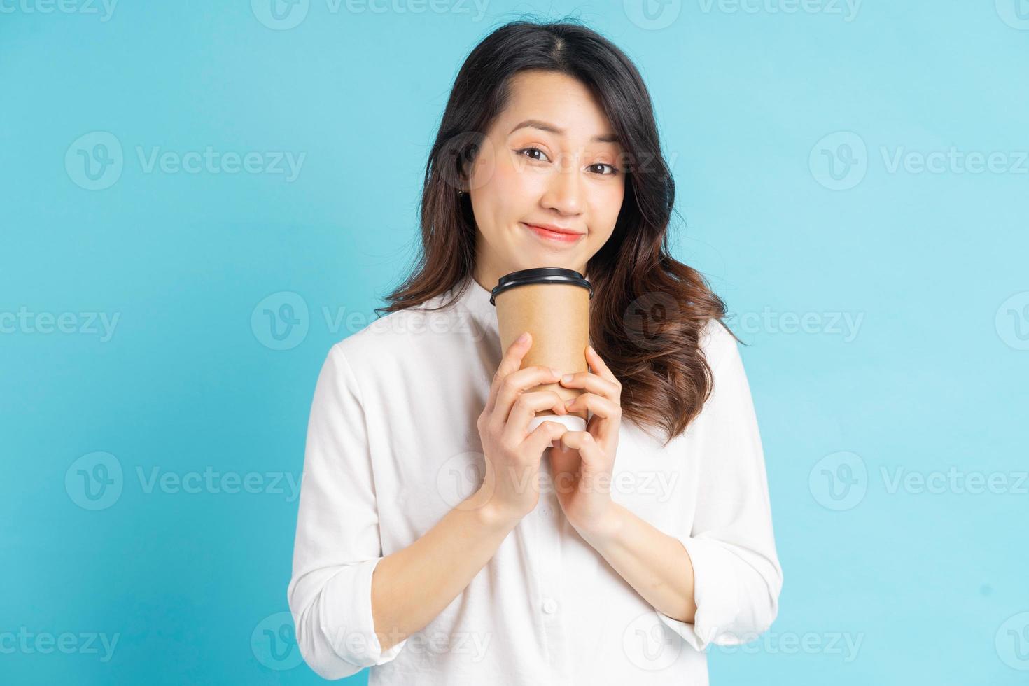 belle femme d'affaires asiatique tenant une tasse de café en papier dans sa main photo