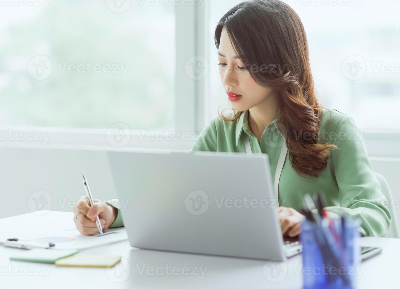 belle femme d'affaires asiatique assise travaillant au bureau photo