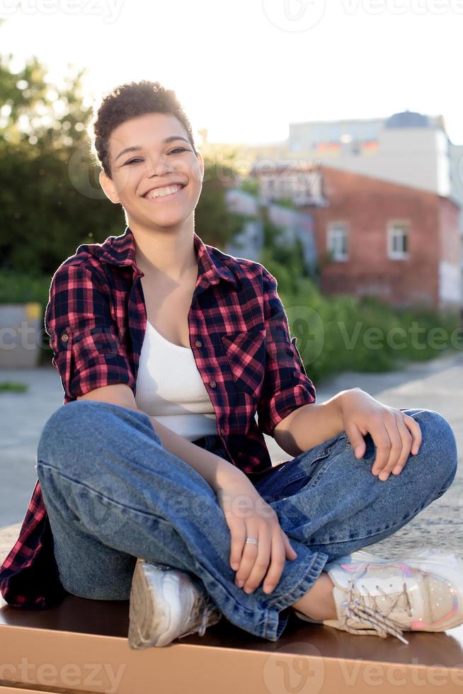 belle femme afro-américaine aux cheveux courts en été dans la rue photo