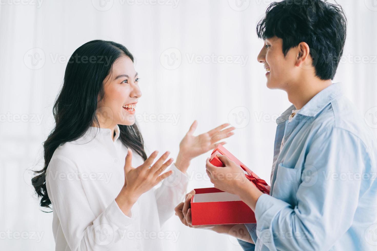 une fille asiatique se sent heureuse et surprise de recevoir des cadeaux de son petit ami le jour de la saint valentin photo