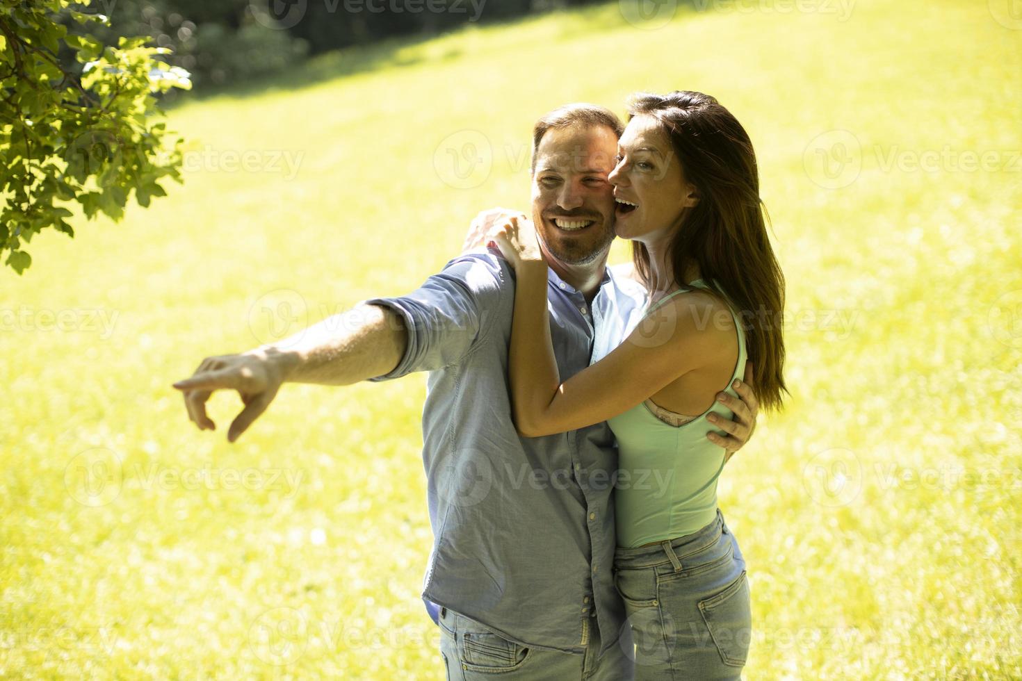 jeune couple affectueux s'amusant sur l'herbe verte photo