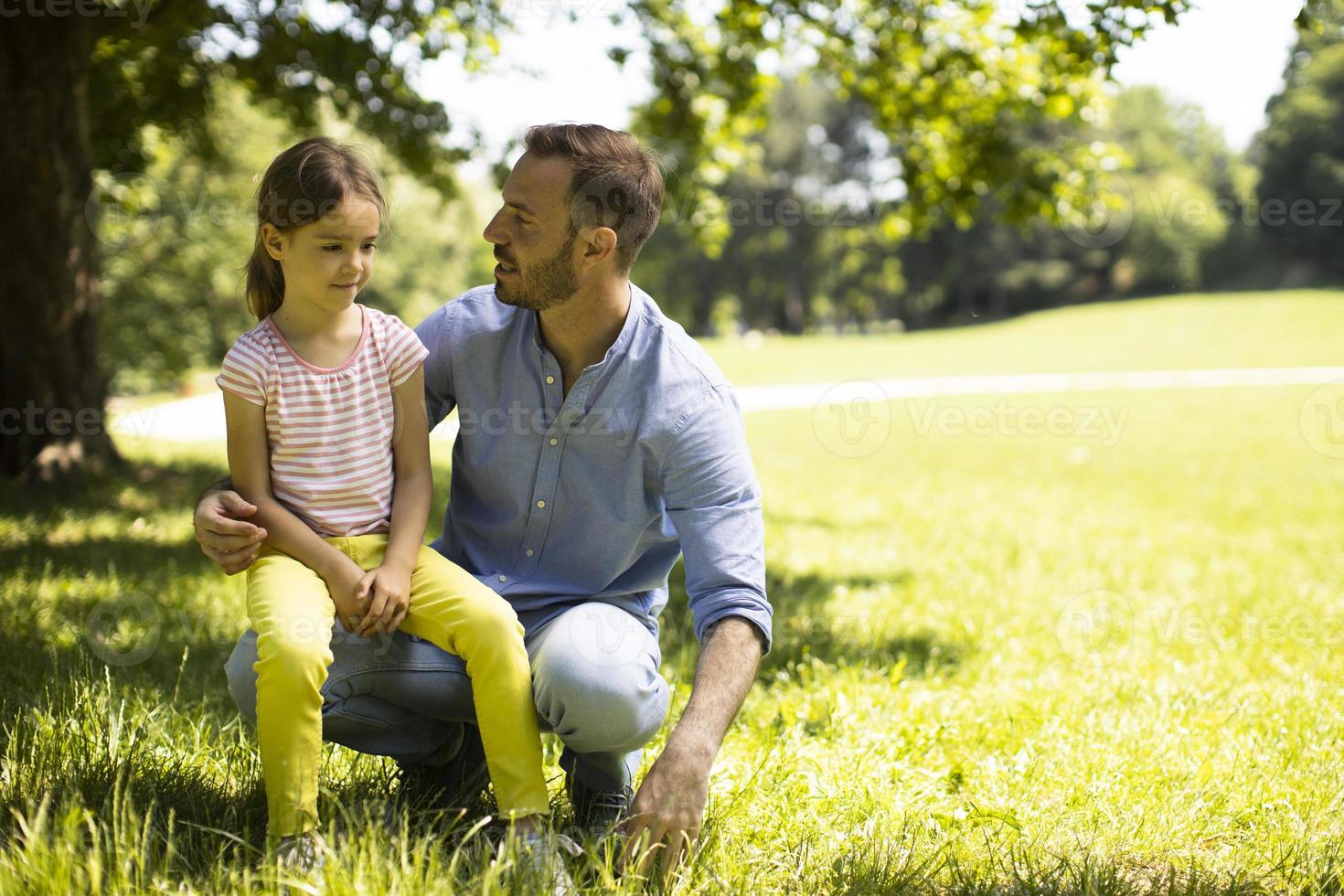 père avec fille s'amusant sur l'herbe au parc photo