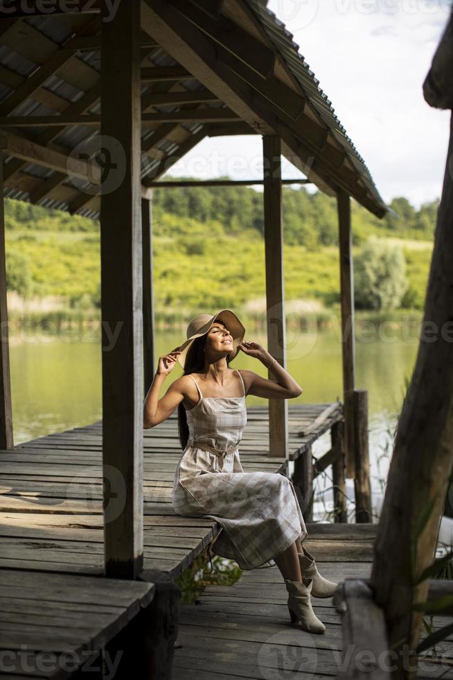 jeune femme relaxante sur une jetée en bois au bord du lac photo