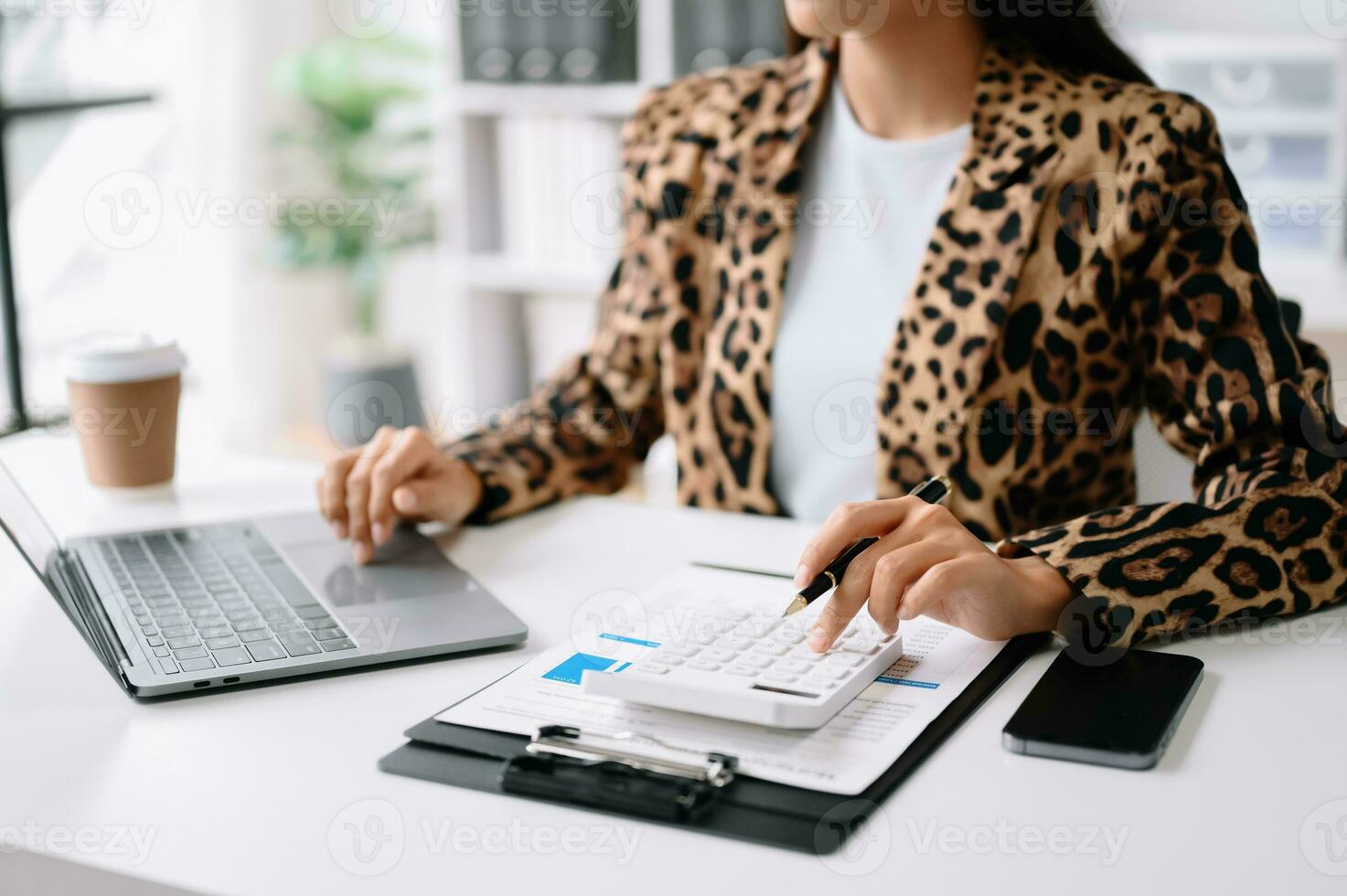 gros plan d'une femme d'affaires ou d'un comptable tapant à la main un ordinateur portable travaillant pour calculer sur le bureau le coût au bureau à domicile. photo